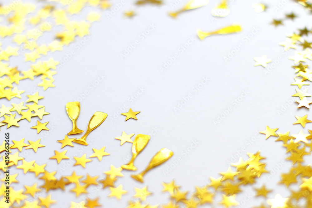 Festive background. Shining confetti stars and glass of champagne on white background. Christmas. Wedding. Birthday. Happy woman`s day. Mothers Day. Valentine`s Day. Flat lay, top view, copy space