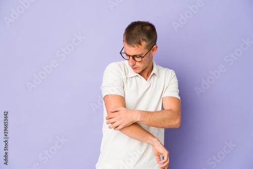 Young caucasian handsome man massaging elbow, suffering after a bad movement.