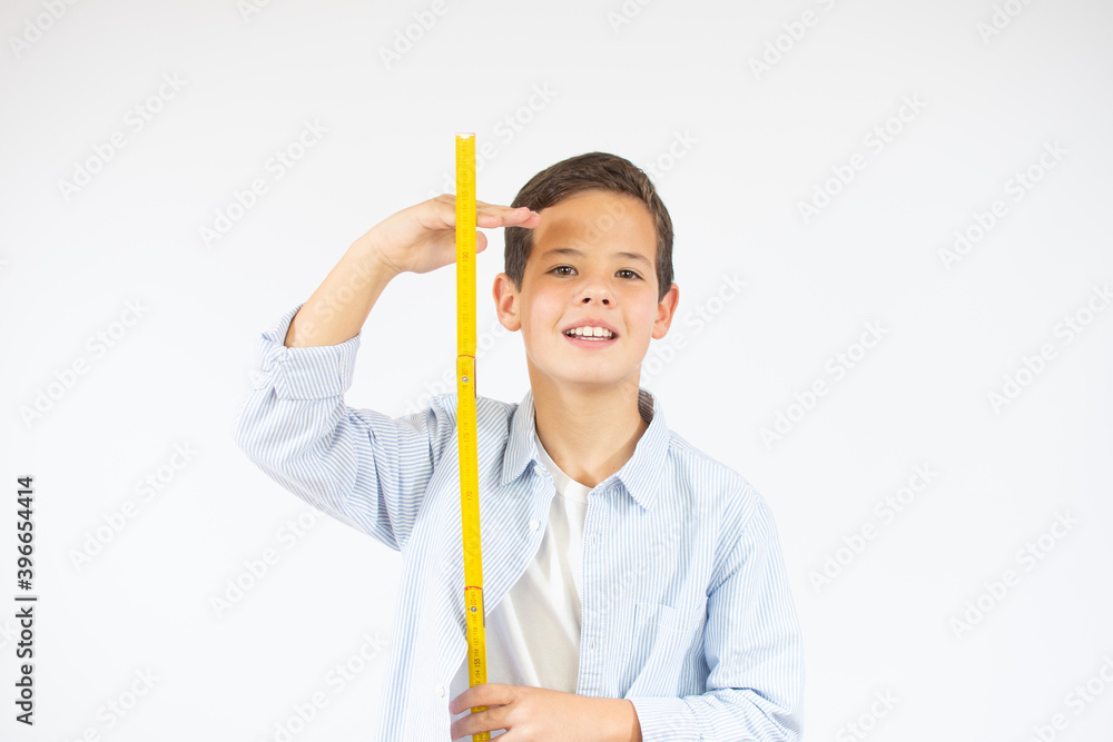 Young beautiful boy measuring his growth in height Young beautiful boy measuring his growth in height