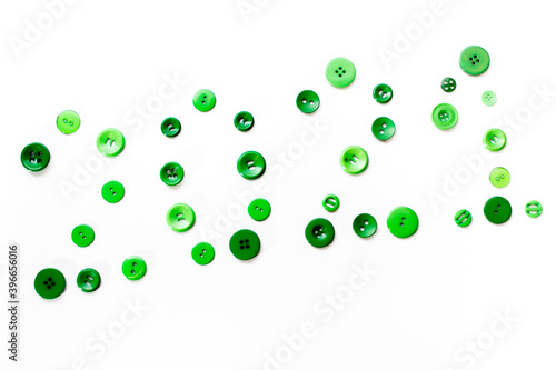 green buttons of different sizes on a white background lined diagonally with the number 2021 new year