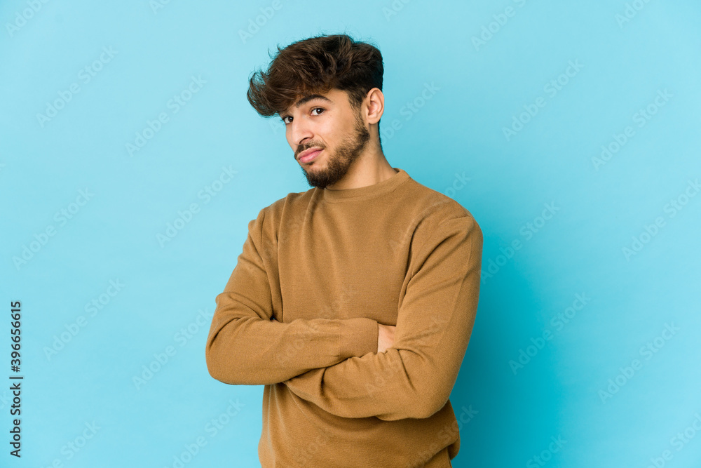Young arab man on blue background unhappy looking in camera with sarcastic expression. Young arab man on blue background unhappy looking in camera with sarcastic expression.