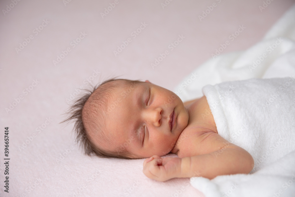 A cute little newborn baby is sleeping on a blanket. A cute little newborn baby is sleeping on a blanket.