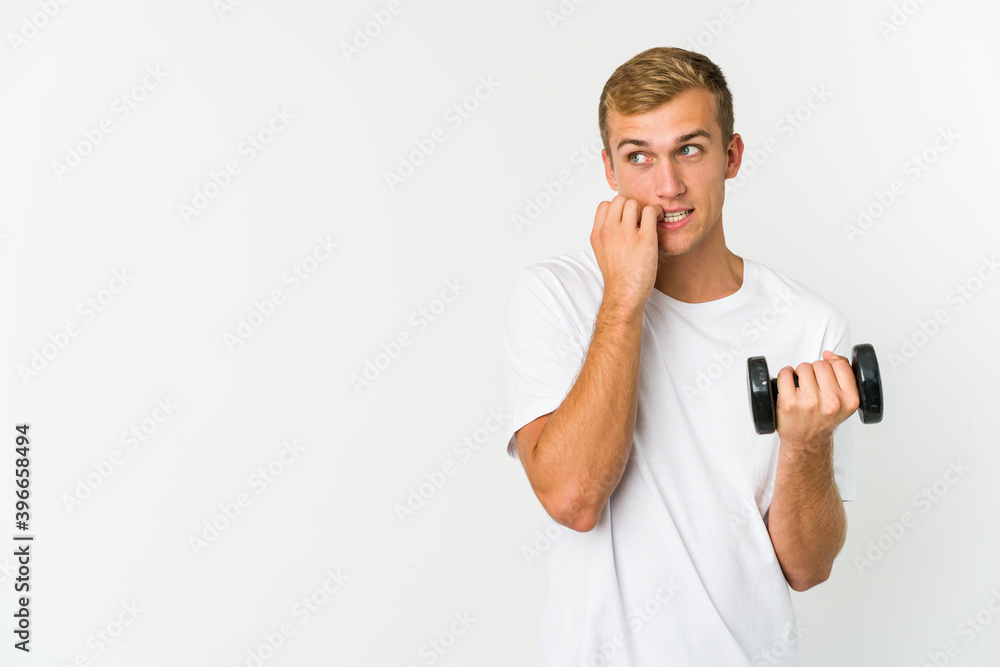 Young caucasian man holding a weight isolated on white background Young caucasian man holding a weight isolated on white background