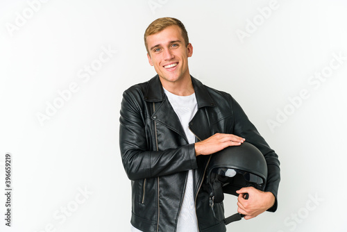 Young caucasian man holding a motorbike helmet isolated on white background