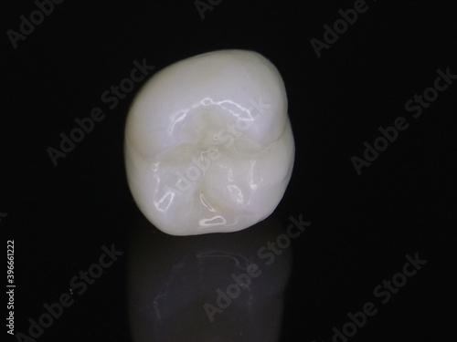 Macro shot of zirconia crown on dark background with reflection
