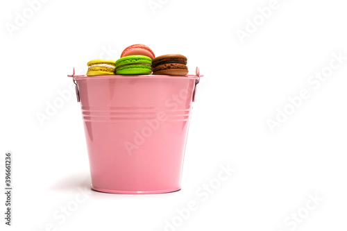 Macarons multicolored in a pink bucket on a white background © ORebrik