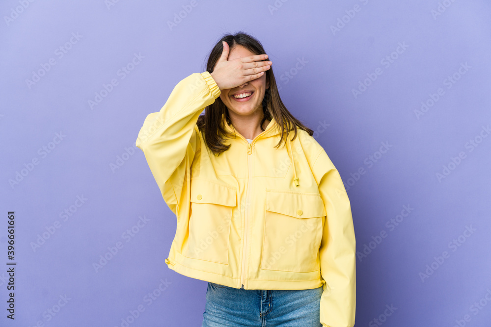 Young caucasian woman covers eyes with hands, smiles broadly waiting for a surprise. Young caucasian woman covers eyes with hands, smiles broadly waiting for a surprise.
