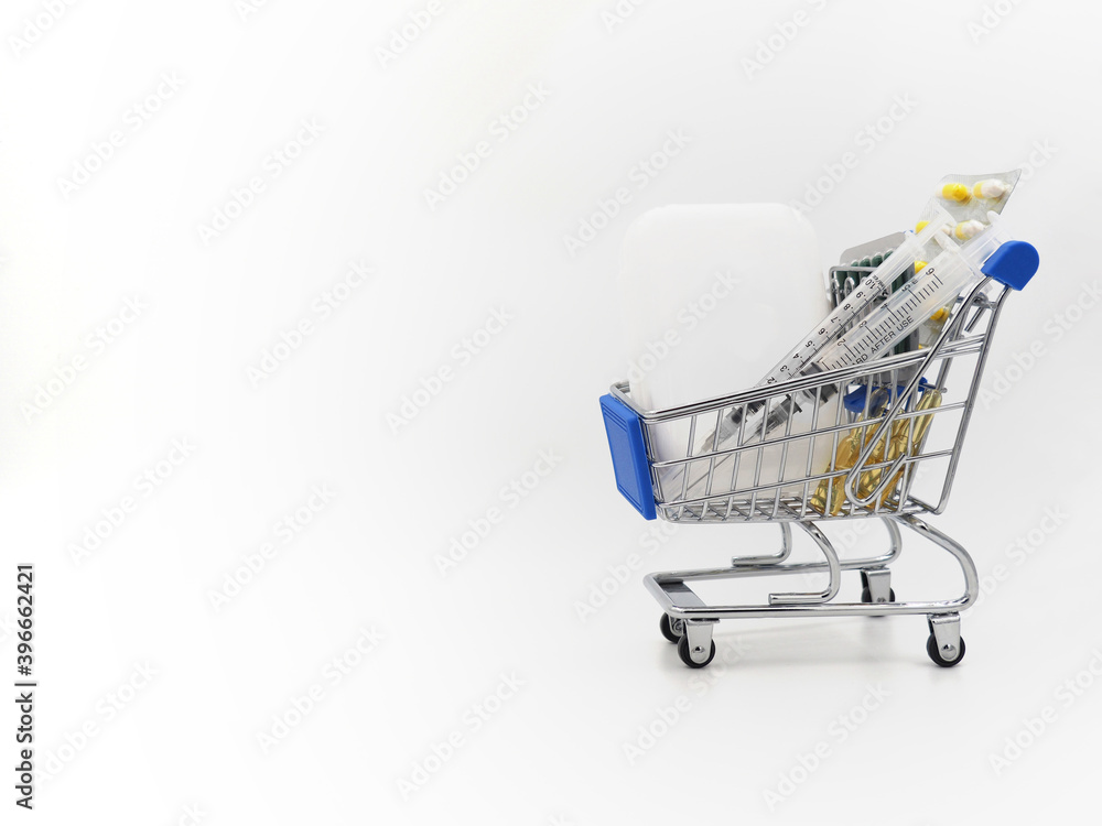 The second, the third wave of coronavirus. Mini shopping cart with medicine from Covid-19. Vaccine, syringes and pills on a light background.