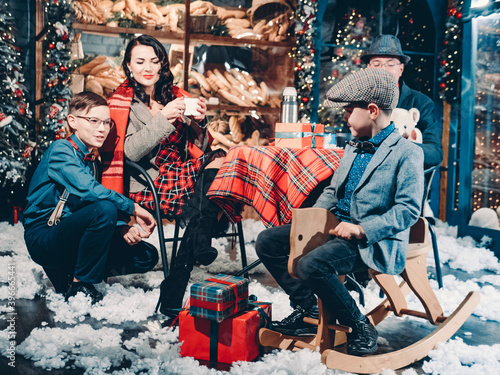 Happy family dressed in retro style in beautiful New Year's decorations. Happy New Years and Christmas Eve Family Celebration Concept.