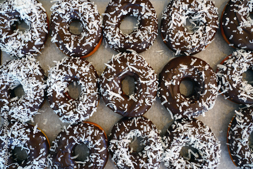 Fresh donuts with chocolate icing and coconut flakes