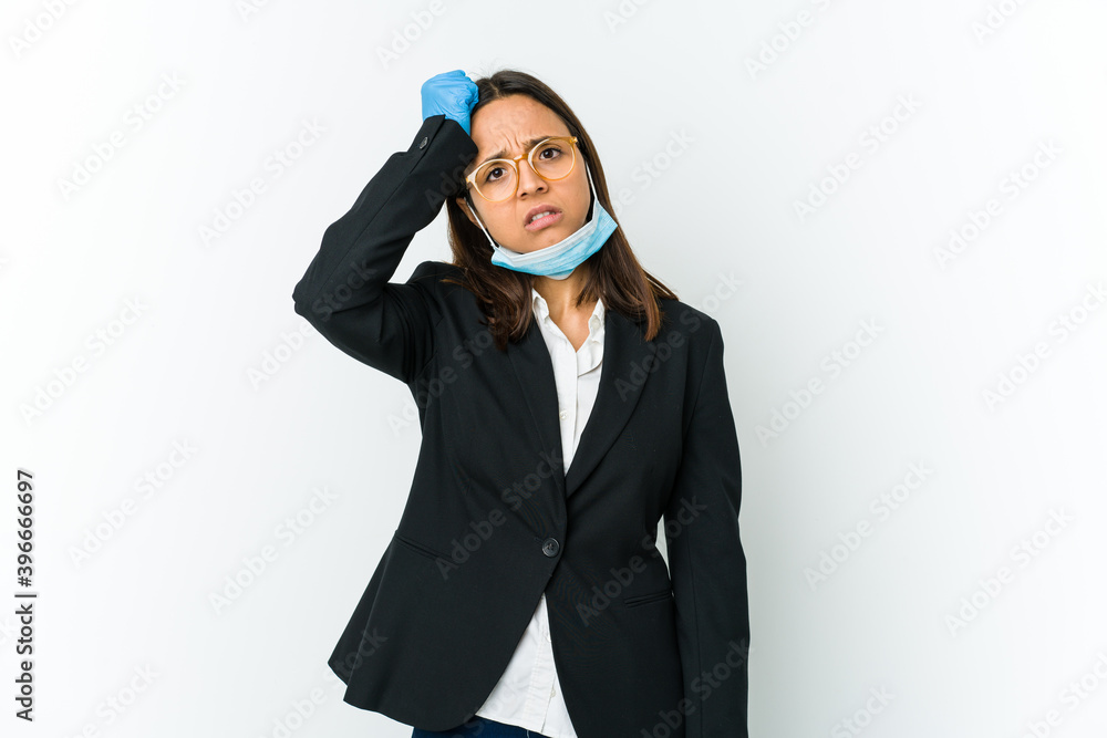 Young business latin woman wearing a mask to protect from covid isolated on white background being shocked, she has remembered important meeting. Young business latin woman wearing a mask to protect from covid isolated on white background being shocked, she has remembered important meeting.