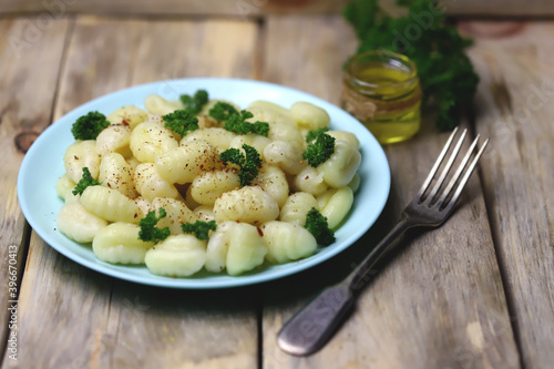 Selective focus. Macro. Gnocchi with olive oil and spices on a plate. A serving of gnocchi.