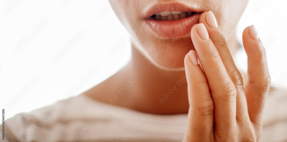 Naklejka premium Young woman suffering from herpes on lips. Treatment of herpes infection and virus 