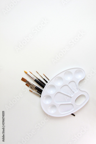 palette for paints and brushes on a white background