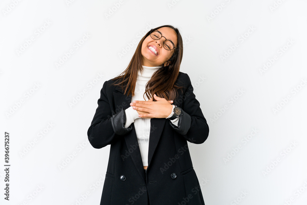 Young mixed race business woman isolated on white background laughing keeping hands on heart, concept of happiness.