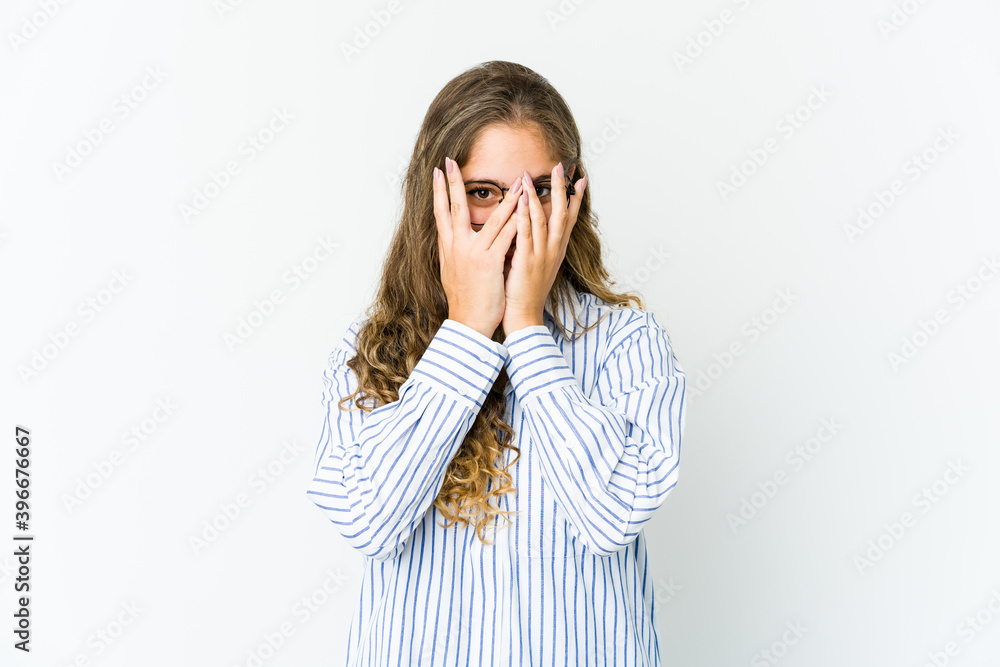 Young caucasian woman blink at the camera through fingers, embarrassed covering face. Young caucasian woman blink at the camera through fingers, embarrassed covering face.