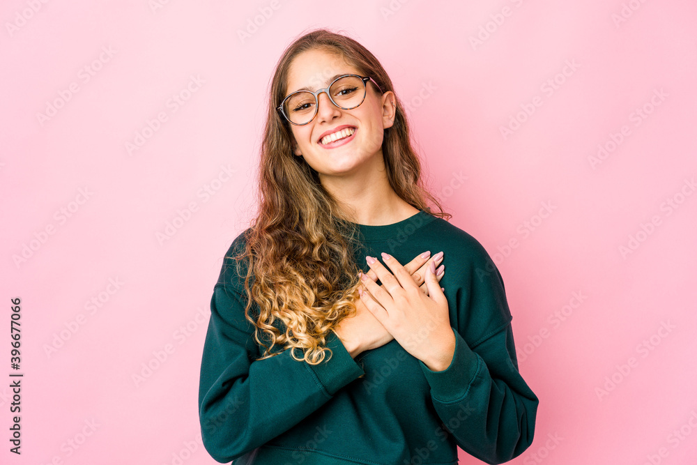 Young caucasian woman laughing keeping hands on heart, concept of happiness. Young caucasian woman laughing keeping hands on heart, concept of happiness.