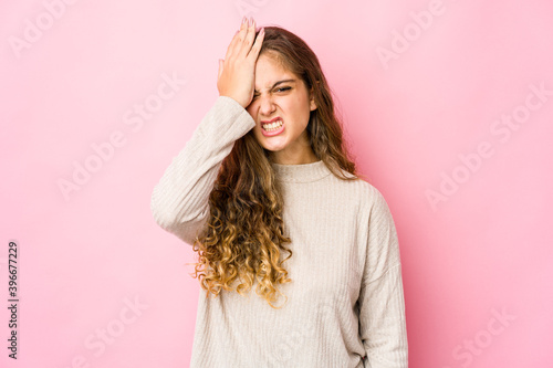 Young caucasian woman forgetting something, slapping forehead with palm and closing eyes.