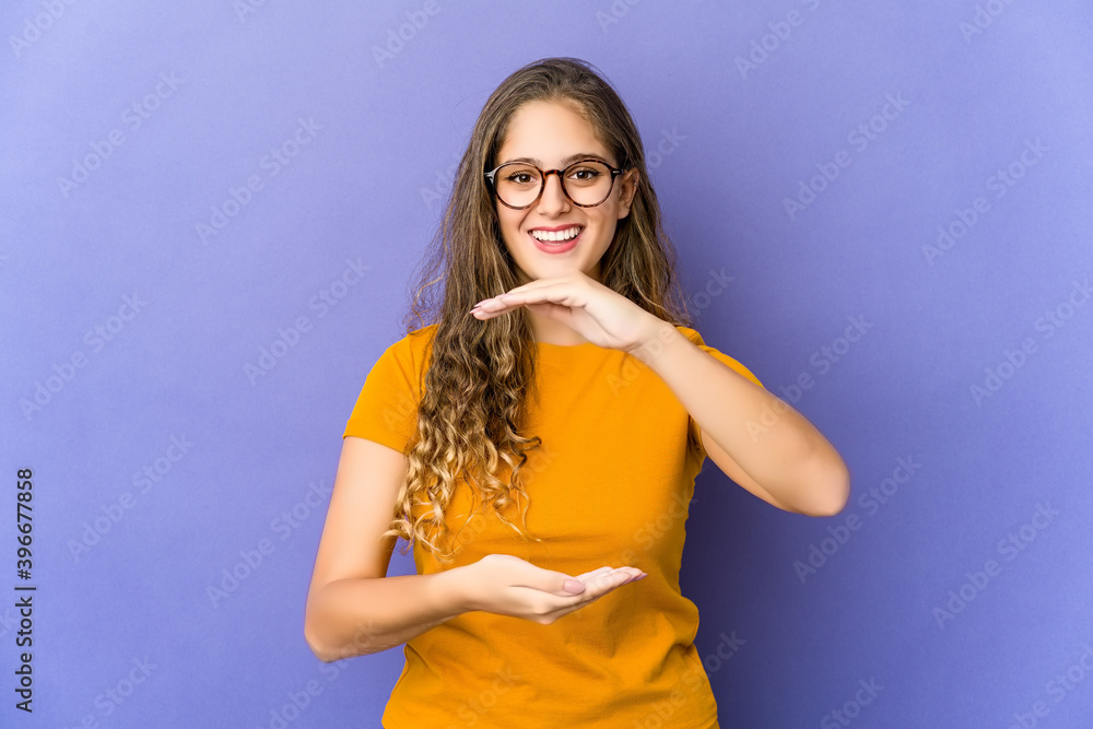 Young caucasian cute woman holding something with both hands, product presentation. Young caucasian cute woman holding something with both hands, product presentation.