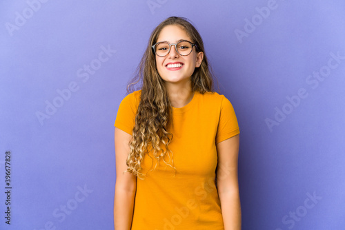 Young caucasian cute woman laughs and closes eyes, feels relaxed and happy.
