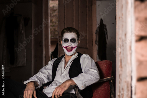 Halloween make up mask. Young man in joker mask.