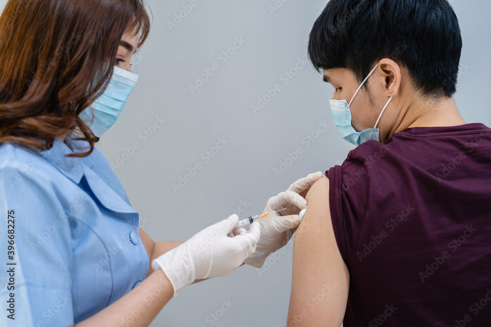 doctor holding syringe and using cotton before make injection to patient in medical mask. Covid-19 or coronavirus vaccine doctor holding syringe and using cotton before make injection to patient in medical mask. Covid-19 or coronavirus vaccine
