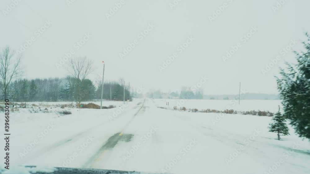 Snow covered road in winter. A POV shot from inside a vehicle during a snow storm. Snow covered road in winter. A POV shot from inside a vehicle during a snow storm.