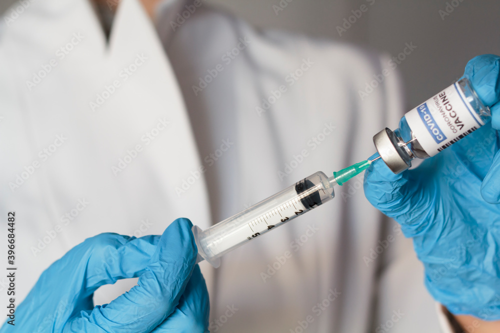 Doctor holding syringe and laboratory injection vial with Coronavirus or Covid-19 vaccine Doctor holding syringe and laboratory injection vial with Coronavirus or Covid-19 vaccine