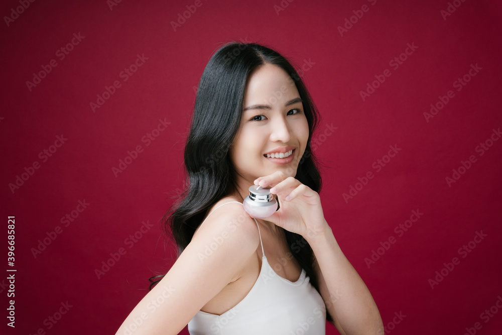 Portrait of beautiful lady holding a cosmetic jar of cream isolated on red background. Portrait of beautiful lady holding a cosmetic jar of cream isolated on red background.