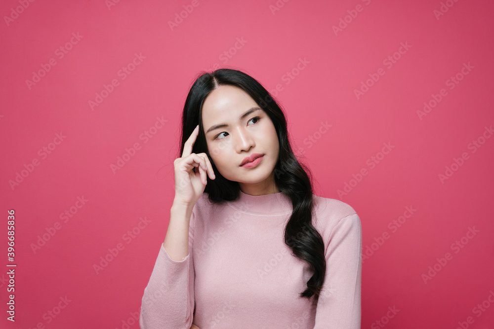 Portrait of asian woman with thoughtful expression isolate on pink background. Portrait of asian woman with thoughtful expression isolate on pink background.