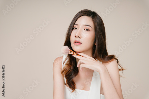 Portrait of beautiful asian woman with cosmetic powder brush.