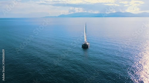 Romantic view of beautiful boat on the sea and majestic mountains in sunlight.