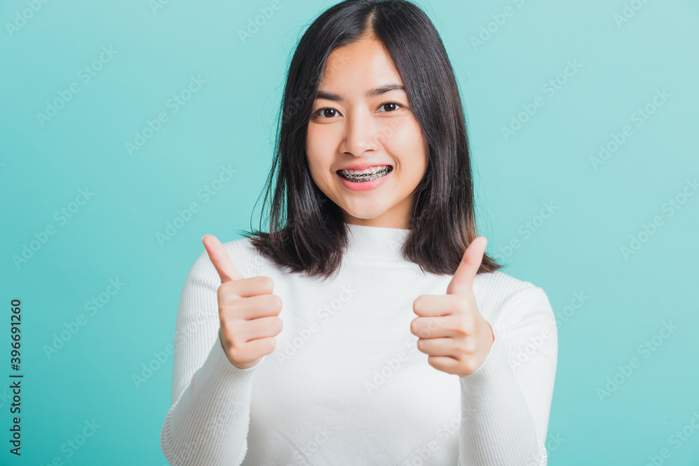 Young beautiful Asian woman cheerful smiling showing finger thumb up, Portrait happy female using showing like the gesture for good sign, studio shot isolated on a blue background Young beautiful Asian woman cheerful smiling showing finger thumb up, Portrait happy female using showing like the gesture for good sign, studio shot isolated on a blue background