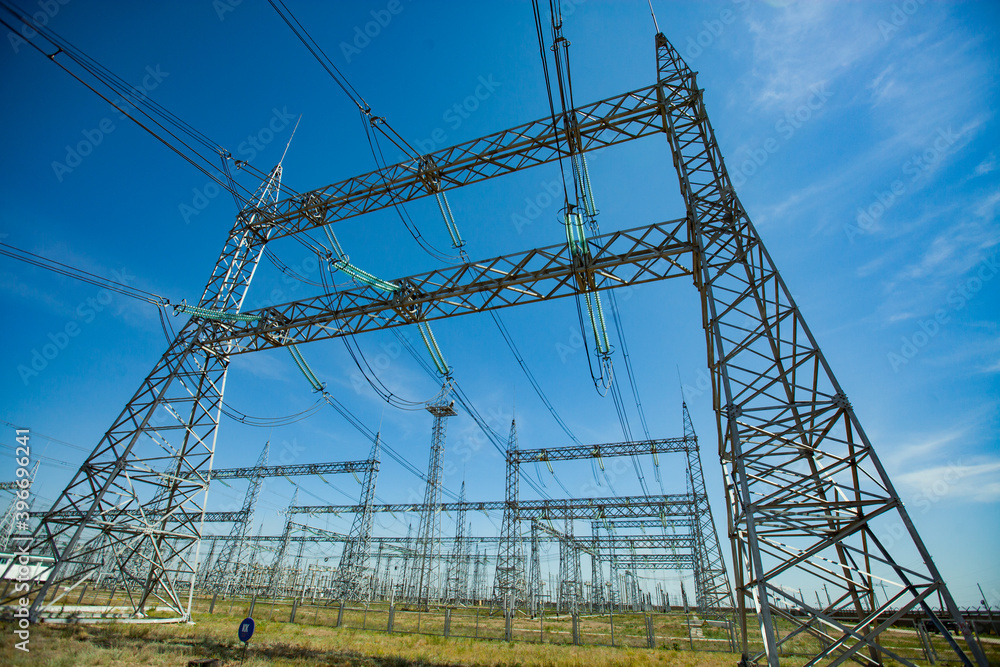 Electric pylons on blue sky with light clouds background. Distribution and transformer substation. Electric pylons on blue sky with light clouds background. Distribution and transformer substation.