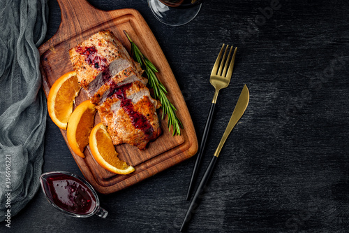 Baked meat with lingonberry sauce on the black background with copy space