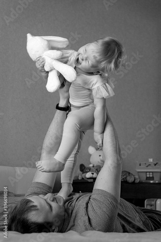 Father with his daughter are happy laughing merrily spending time at home. Black and white photo. photo