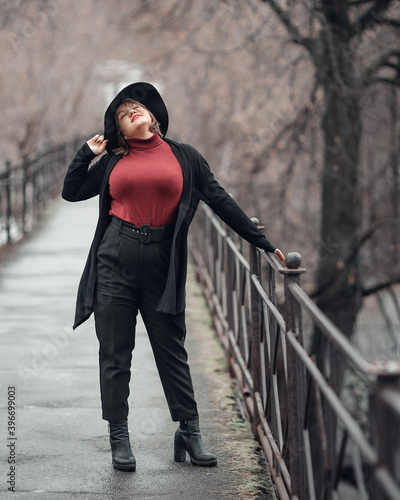 Obraz na płótnie Brunette girl in hat on the bridge in city. Plus size model w salonie