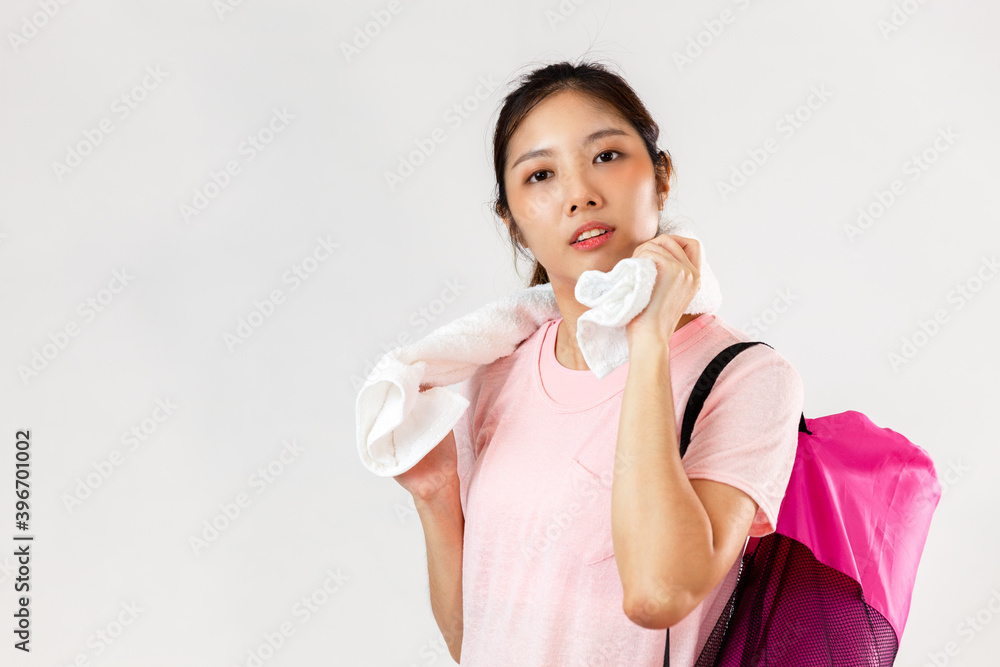 Asian woman smiling while holding yoga mat and water bottle ready for yoga
Asian woman smiling while holding yoga mat and water bottle ready for yoga