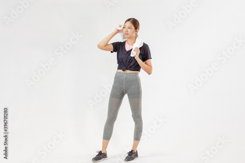 Asian woman standing on a white wall background with copy space, exercises for weight loss, flexibility and toning.