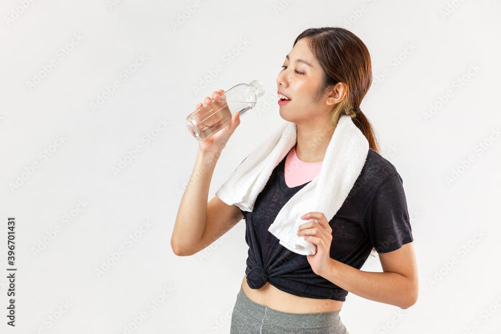 Asia cute woman in sport ware standing on white background and drinking water after exercising.
Asia cute woman in sport ware standing on white background and drinking water after exercising.