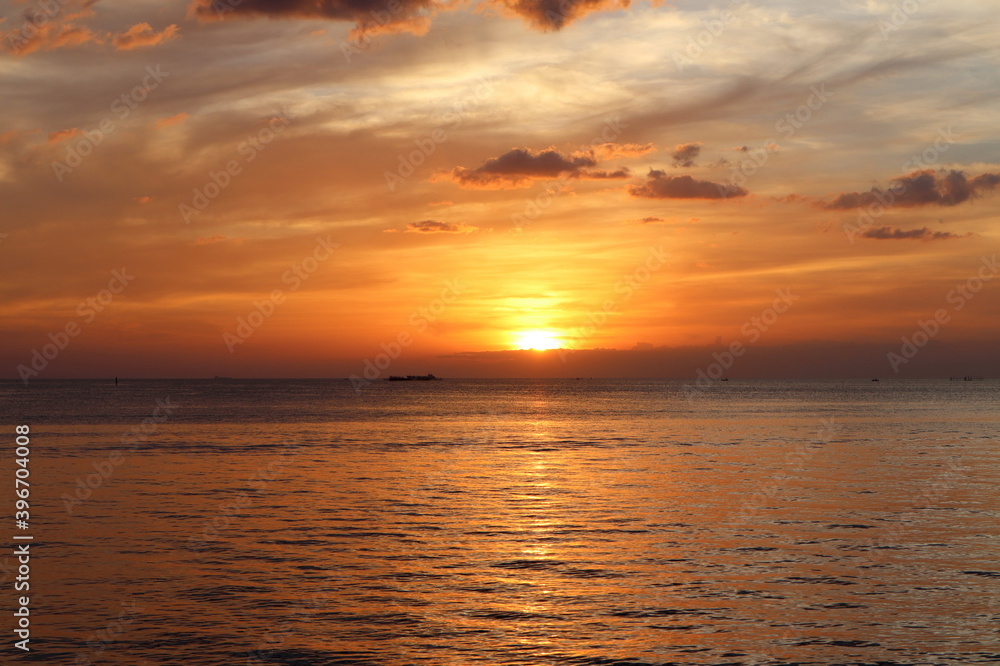 Obraz premium landscape photo of sunset reflect over the sea with clouds in the sky at the beach with shadow of rocks in the summer at Pattaya beach Thailand