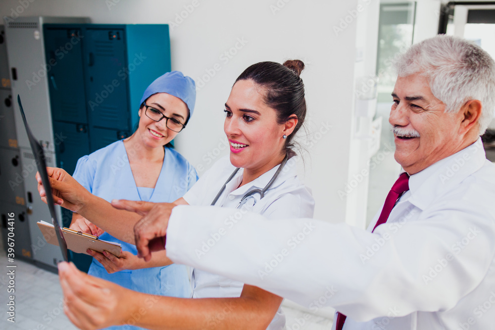 Obraz premium Group of latin doctors looking a radiography in a hospital