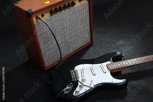 Fotografía Brown guitar combo amplifier with black guitar on black background