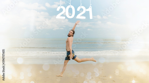 New Year concept. A man in shorts runs along the beach against the background of the sea. Inscription 2021