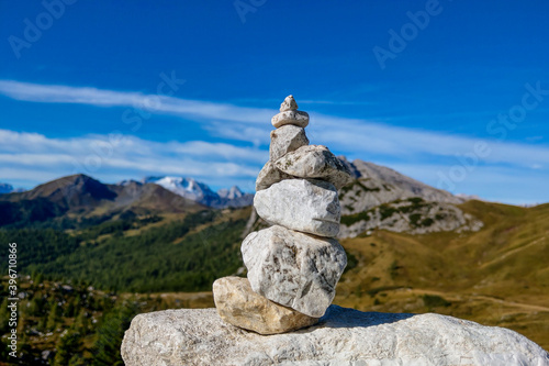 Several pebbles one by one against the background of the mountains. © Dzmitry