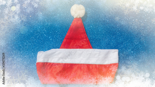 Santa Claus hat on a blue Christmas background top view. New Year concept