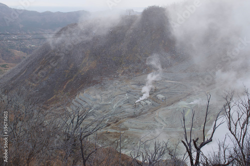 In the volcanic area around Mt Fuji in Japan, many dead trees and a barren landscape can be seen, Sulphur vapor rises into the sky it is void of people. © Dane