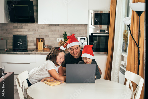 Dad and two children video chatting online on the occasion of Christmas celebration. Holiday at home