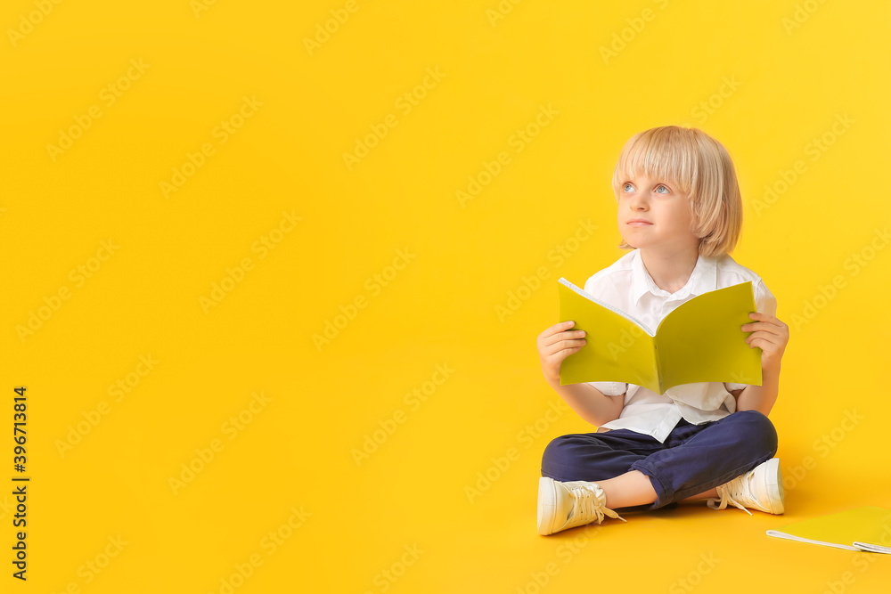 Cute little boy with notebooks on color background Cute little boy with notebooks on color background