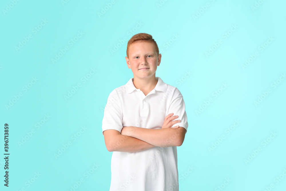 Smiling teenage boy with crossed arms on color background Smiling teenage boy with crossed arms on color background
